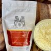 picture of package of golden milk mix also known has haldi doodh made from tumeric and spices. Also pictured a cup of prepared golden milk with foam.