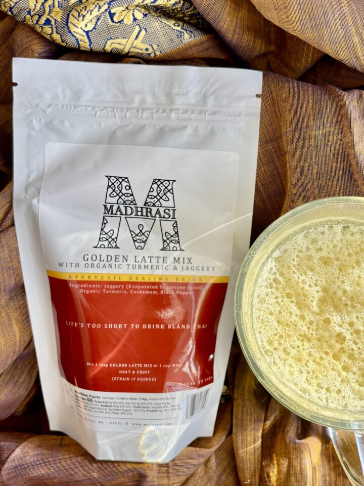picture of package of golden milk mix also known has haldi doodh made from tumeric and spices. Also pictured a cup of prepared golden milk with foam.